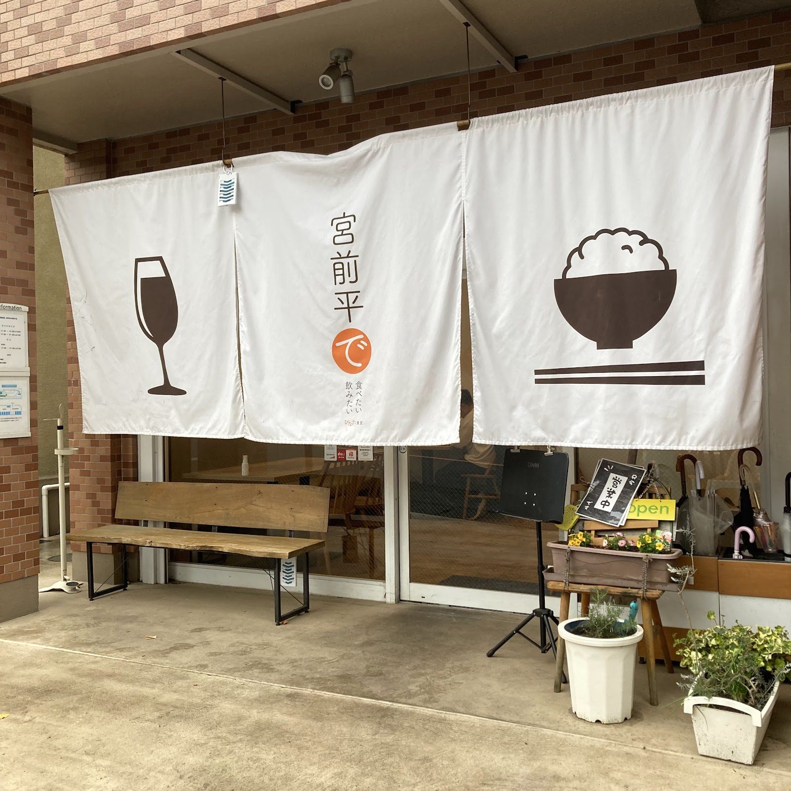 ひなた食堂|店の外壁に貼られた複数の白いのれんと看板