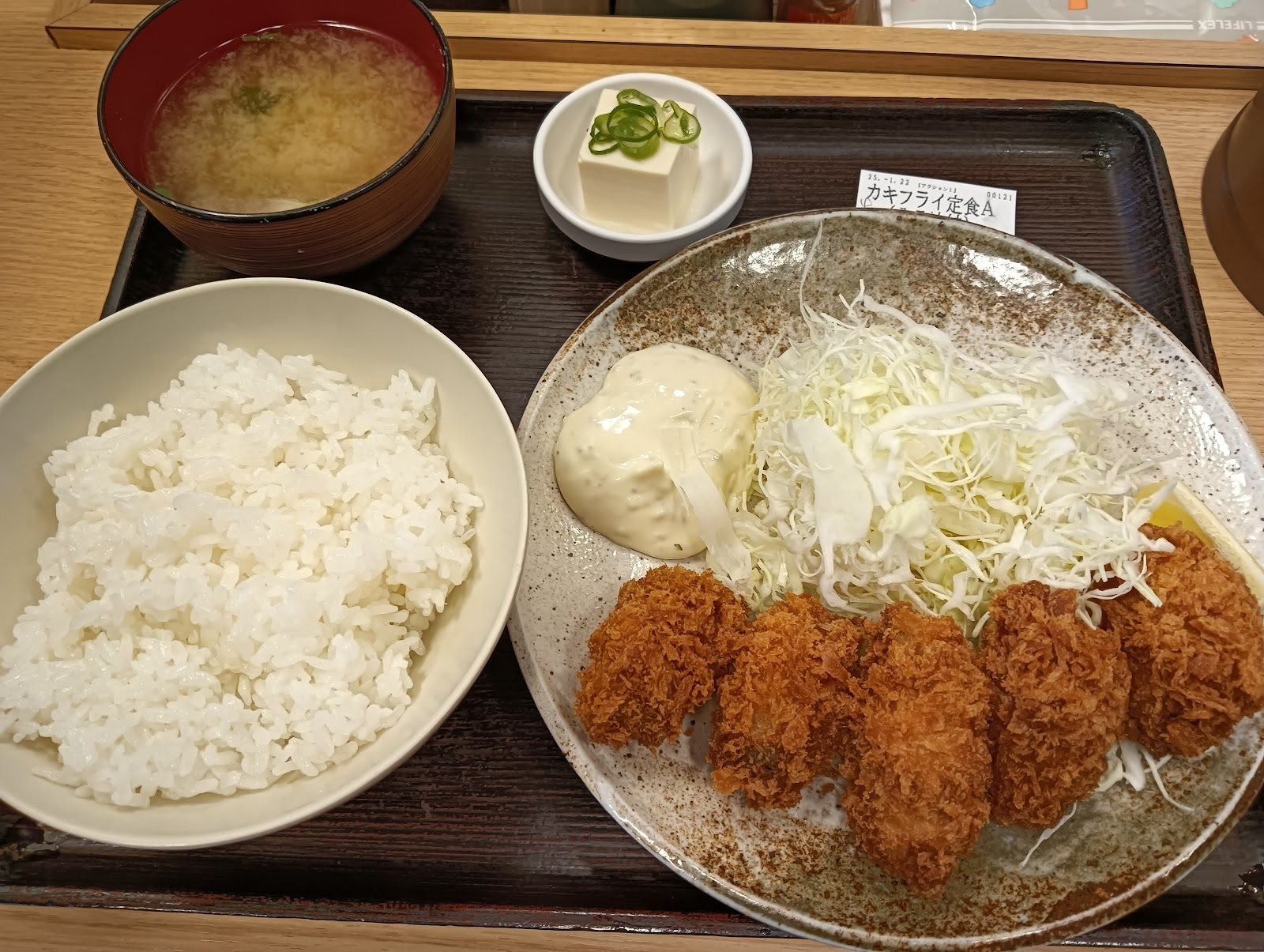 カキフライ定食。ご飯、味噌汁、冷奴、カキフライとキャベツが載る