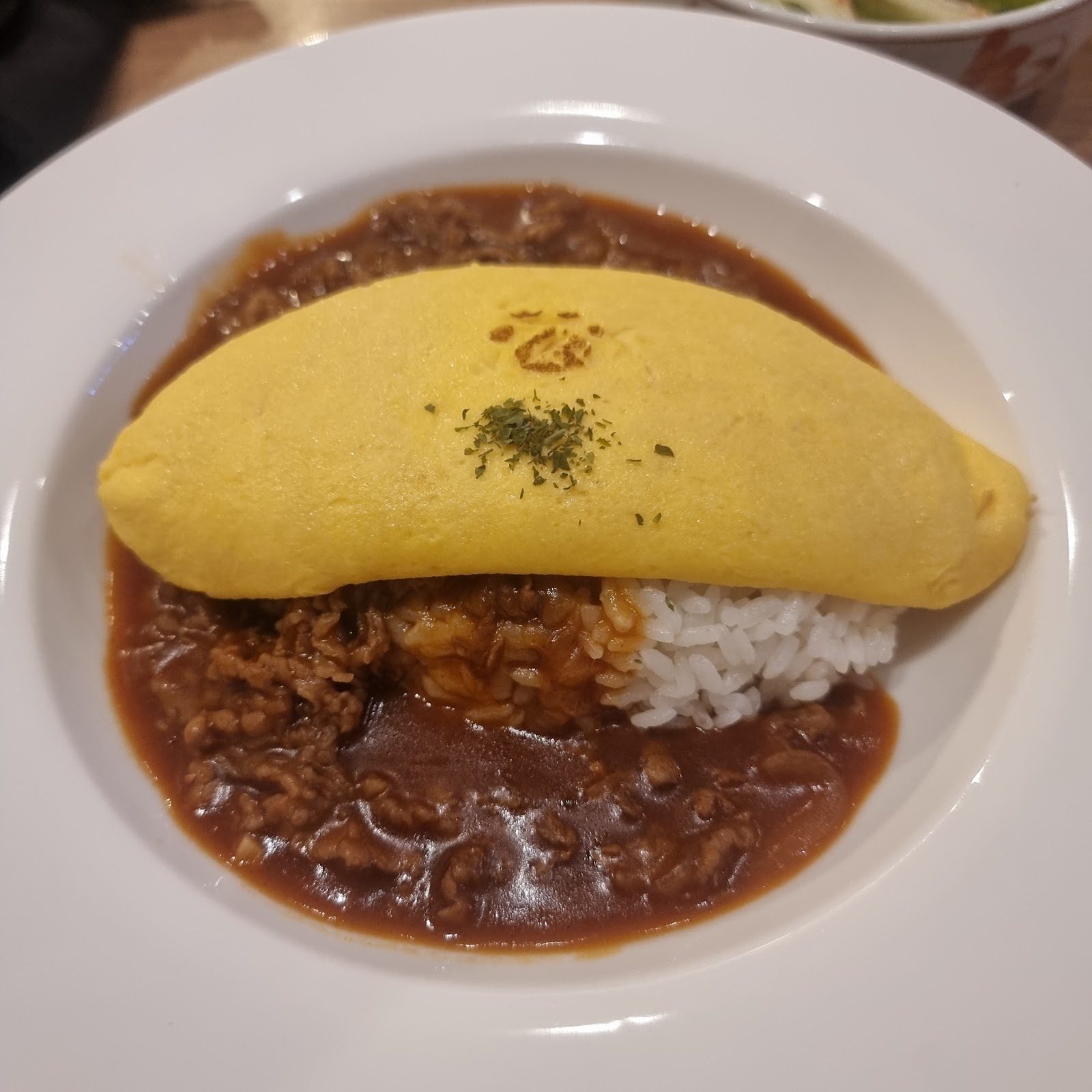 オムライスの上に黄色い卵がのった料理
