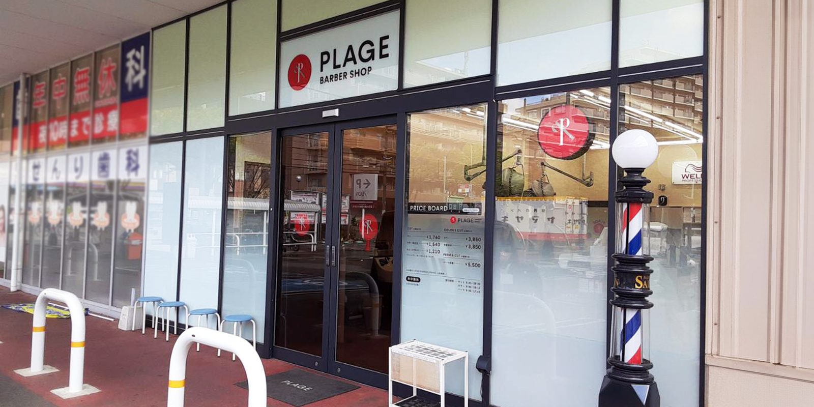 プラージュ 千里丘店|PLAGE BARBER SHOPのガラス張りの店舗外観と赤白青の理容ポール