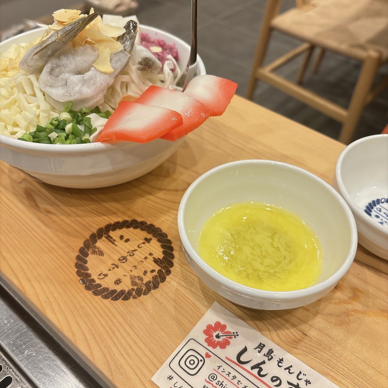トッピングをのせたもんじゃ焼きが複数の皿に盛り付けられている