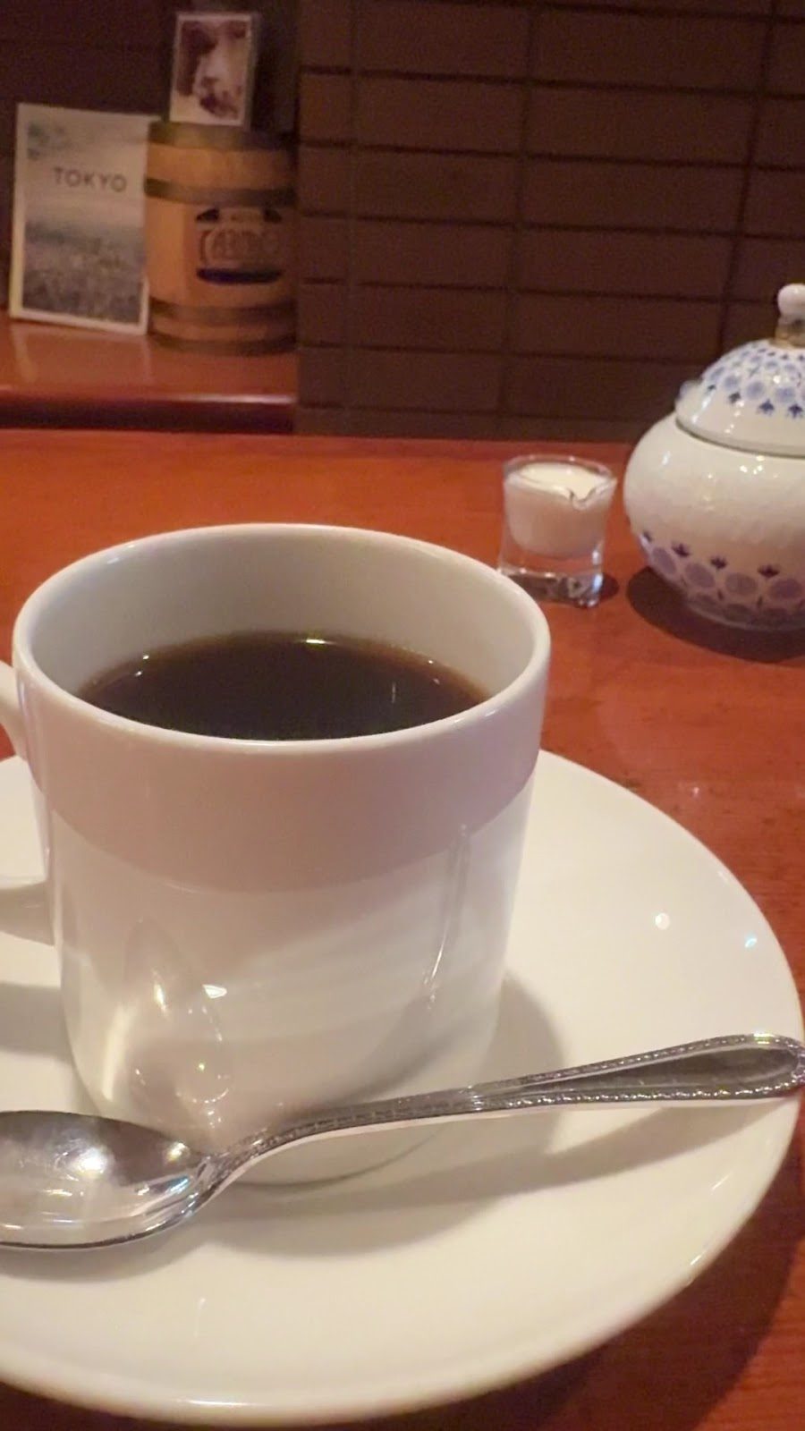 白いカップに注がれた黒いコーヒーと銀色のスプーン