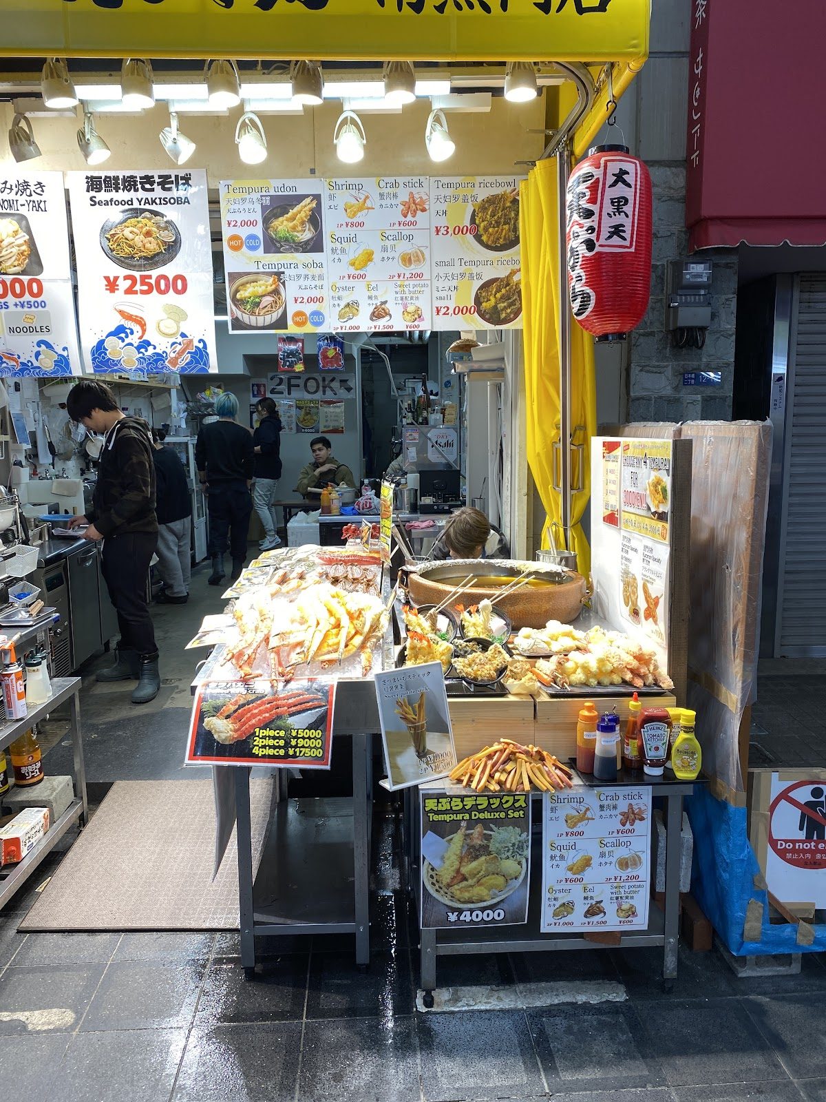 天ぷらの盛り合わせと海鮮焼きの品書きが並ぶ店内の様子