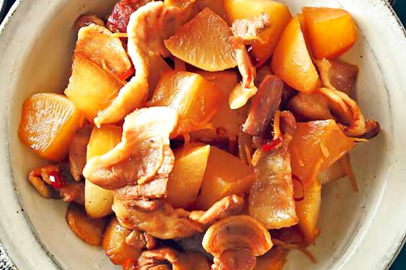 白い皿に盛られた、黄色と赤色の食材が混ざった料理