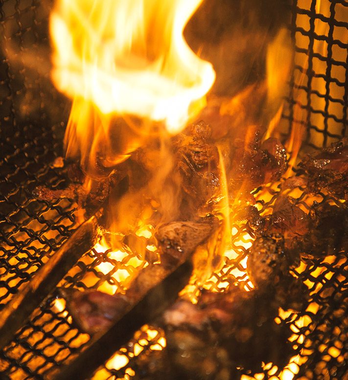 炭火で焼かれる焼き鳥の串が並ぶ様子