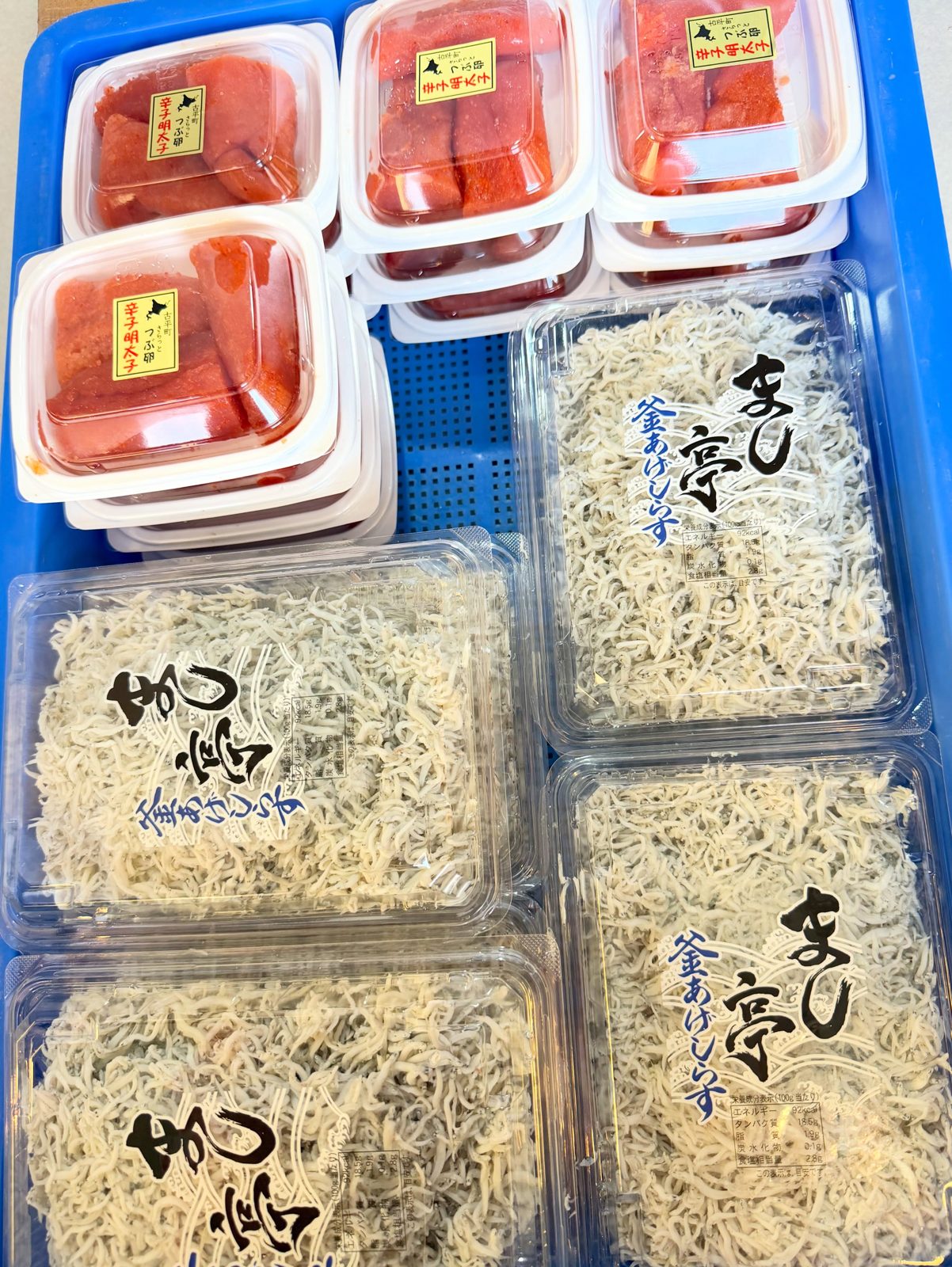 パックに入った赤い食材と白い小魚の加工品が並んでいる様子