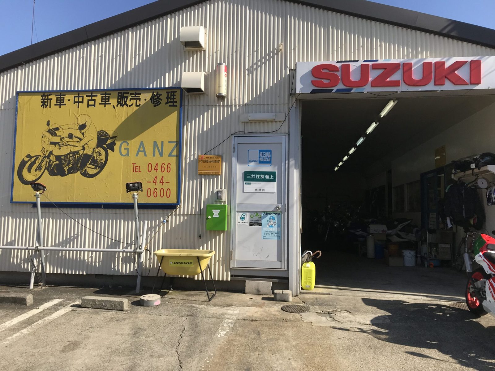 SUZUKIの看板が並ぶ店舗の外観、黄色い看板と駐車場