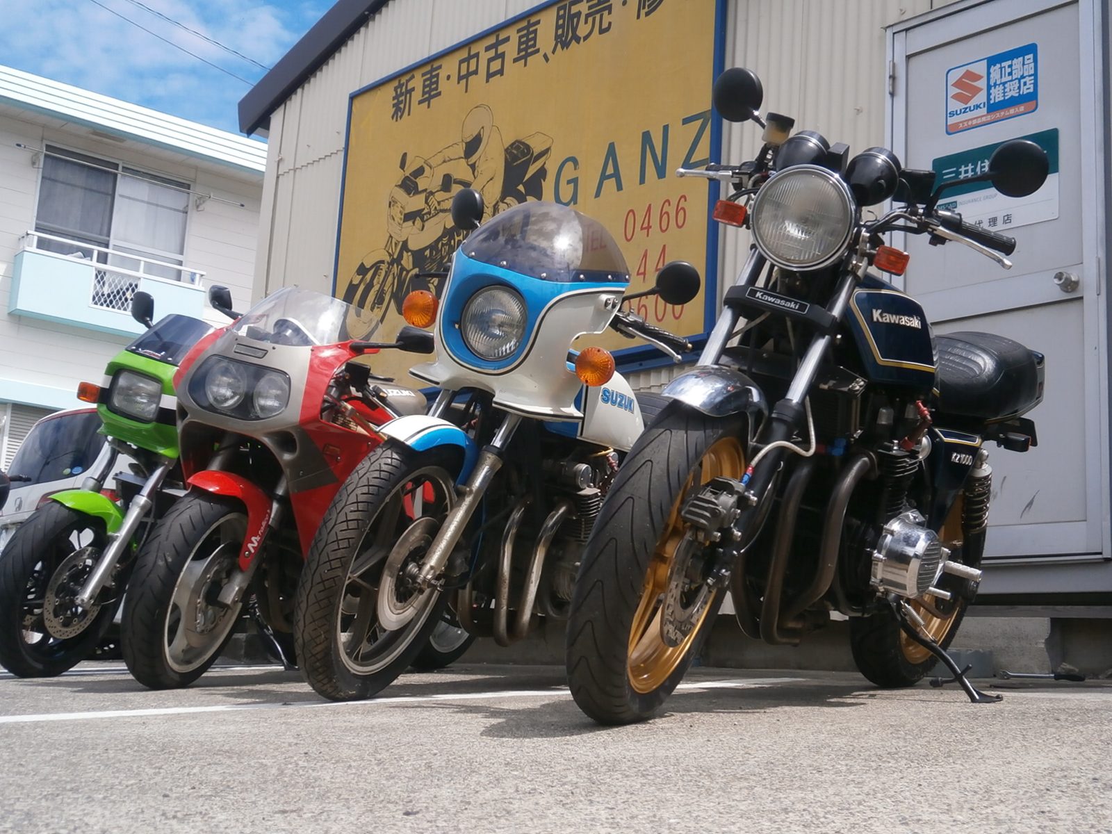 店舗の壁に貼られた多数のバイクのステッカーと看板