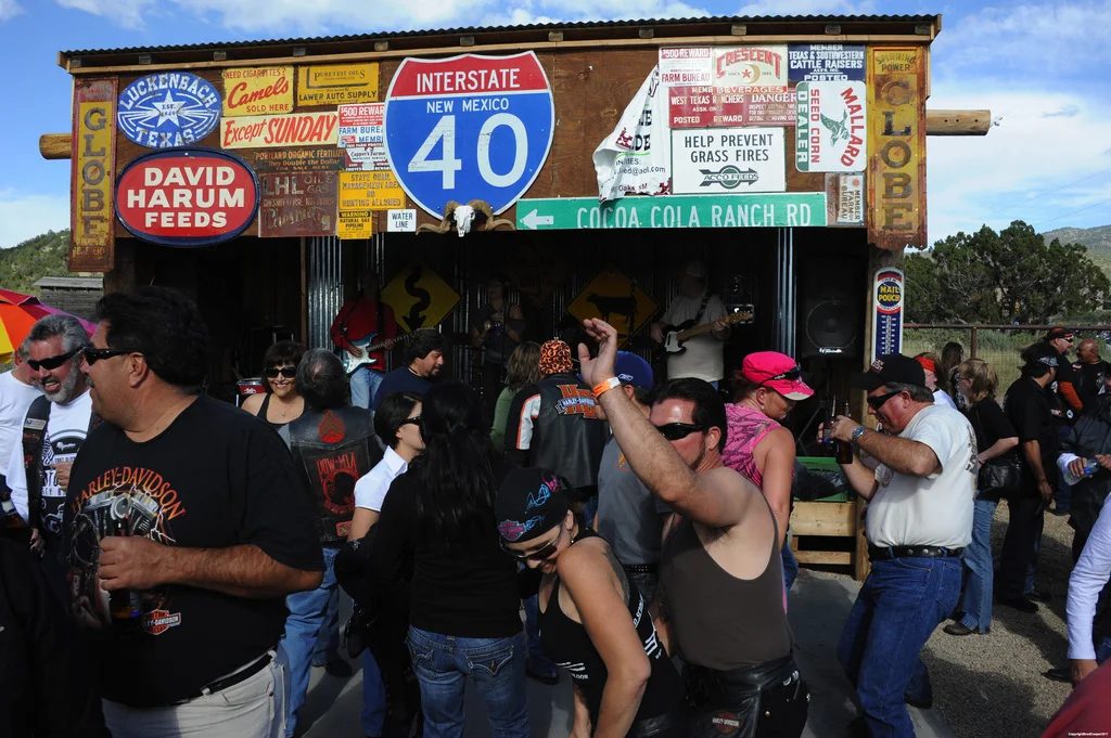 People gathering outdoors among rows of colorful signs