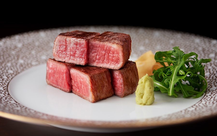 松阪牛の赤身肉を盛り付けた皿に、わさびと葉物の添え