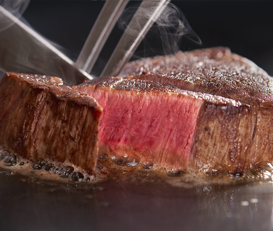 鉄板で焼かれる肉料理のクローズアップ